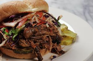Pulled pork sandwich with coleslaw and pickles.