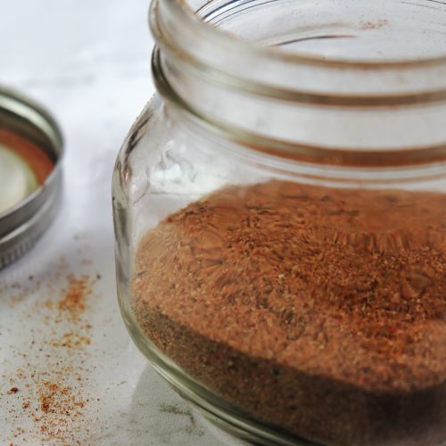 A jar of dry spice rub for ribs.
