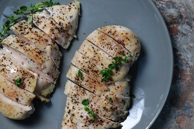 Two perfectly bakes chicken breasts sprinkles with green herbs. Delicious!
