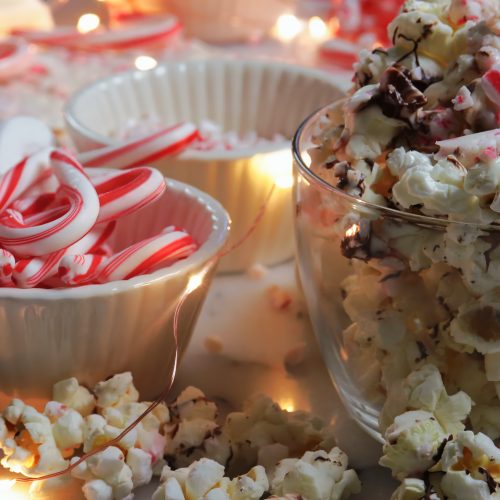 Fluffy light popcorn drizzled with dark chocolate and bits of crunchy peppermint candy canes make candy cane popcorn.