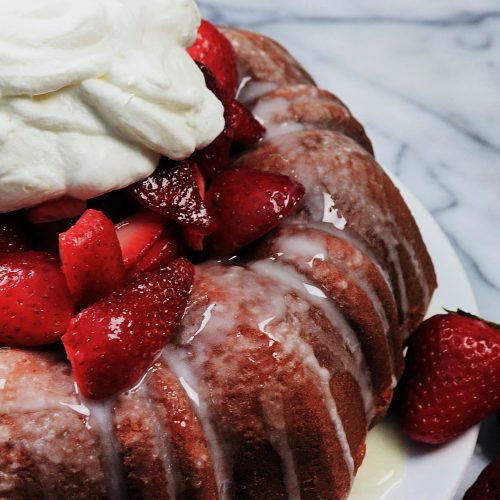 Buttery golden bundt cake with a tender crumb, overflowing with juicy fresh strawberries and billowy clouds of vanilla whipped cream.