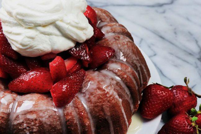Buttery golden bundt cake with a tender crumb, overflowing with juicy fresh strawberries and billowy clouds of vanilla whipped cream.