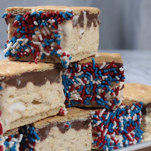 Delicious ice Cream sandwiches with s'mores ingredients hidden inside. There's toasted marshmallows and chocolate ganache sandwiched by graham crackers. Frozen treat!