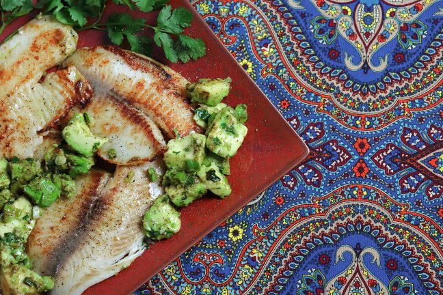 A plate of golden tilapia with a luscious warm tomato and avocado salsa.