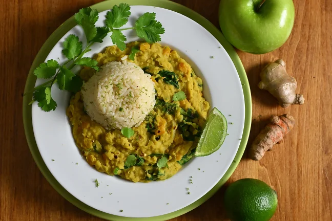 A delicious bowl of golden coconut dal, a soup made with orange lentils, ginger, turmeric and grated apple.