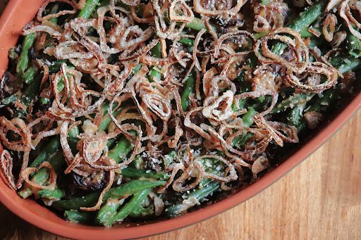Casserole dish filled with homemade green bean casserole topped with crispy fried shallots.