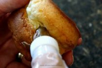 Piping chocolate filling into popover